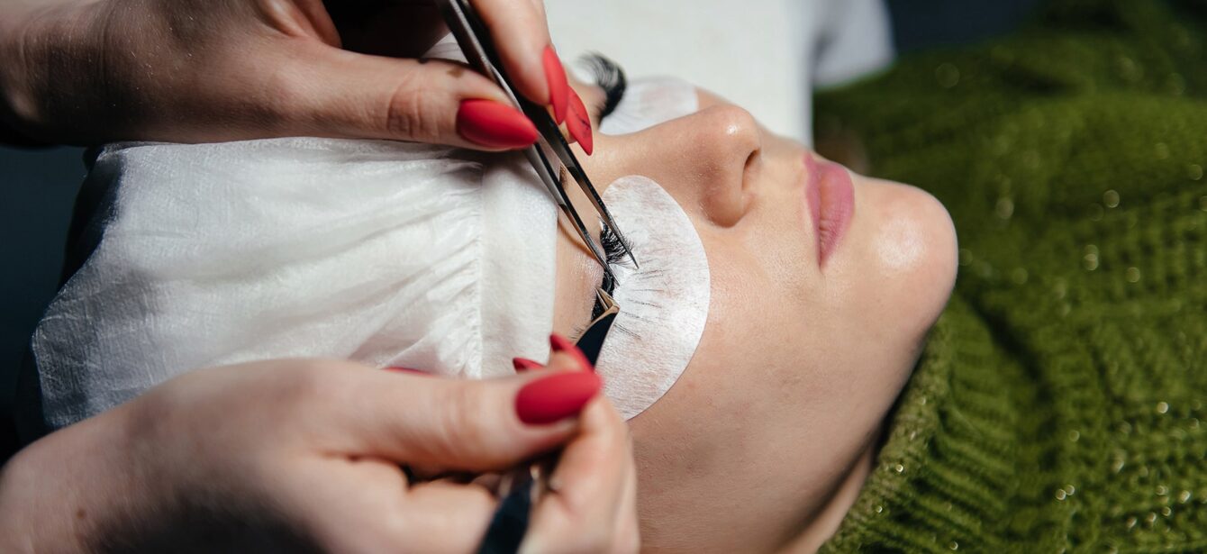 eyelash-extension-process-closeup-portrait-young-girl-woman-with-long-thick-eyelashes-eyes-closed-hand-cosmetologist-adding-more-eyelashes-her eyelash-extension-process-closeup-portrait-young-girl-woman-with-long-thick-eyelashes-eyes-closed-hand-cosmetologist-adding-more-eyelashes-her