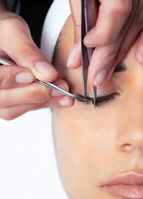 shot-cosmetologist-doing-eyelash-extension-procedure-woman-white-background shot-cosmetologist-doing-eyelash-extension-procedure-woman-white-background
