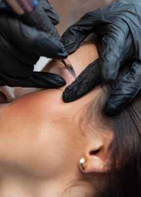 young-woman-getting-beauty-treatment-her-eyebrows young-woman-getting-beauty-treatment-her-eyebrows