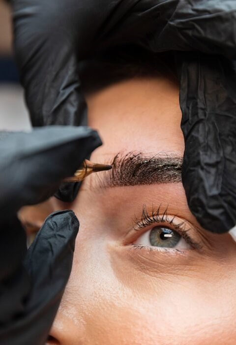 young-woman-getting-beauty-treatment-her-eyebrows young-woman-getting-beauty-treatment-her-eyebrows